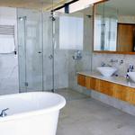 High end Master bath design with frameless shower doors, claw foot tub, and designer vanity bowls.